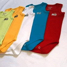 a row of baby onesie 's with the letters nb on the front