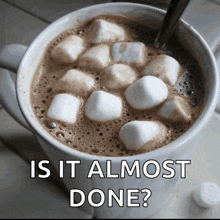 a mug of hot chocolate with marshmallows and the words is it almost done