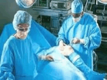 two surgeons are operating a patient in an operating room .