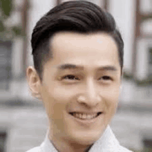 a close up of a man 's face smiling with a building in the background .