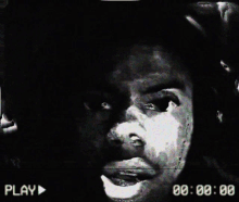 a black and white video of a man 's face with the play button in the corner