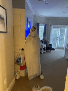 a person wrapped in a blanket is standing in a living room next to a bag that says the brew