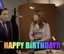 a man in a suit and tie is standing next to a woman in a birthday hat who is saying happy birthday !