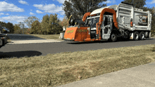 a premier garbage truck is driving down the road