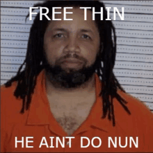 a man with dreadlocks and a beard is wearing an orange shirt with the words free thin he aint do nun on it