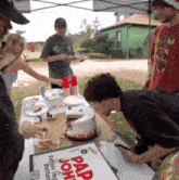 a group of people are gathered around a table with a cake that says " pap john " on it