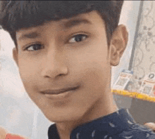 a close up of a young boy 's face with a blue shirt on .