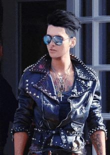 a man wearing sunglasses and a leather jacket with studs on it