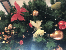 a christmas tree is decorated with red and gold ornaments