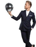 a man in a suit is holding a disco ball in his right hand