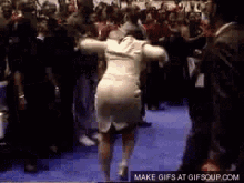 a woman in a white dress is dancing in front of a crowd with a make gifs at gifsoup.com watermark