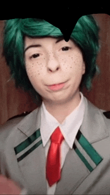 a woman with green hair and freckles wearing a suit and tie