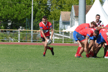 a rugby player wearing a red jersey with the word rugby on the front