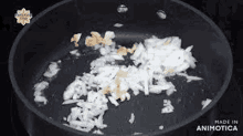 chopped onions and garlic are being cooked in a pan on a stove .