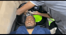 a man with a beard is getting his hair washed in a sink .