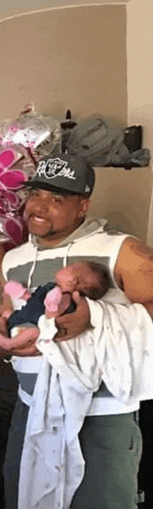 a man wearing a hat is holding two babies in his arms .