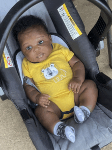 a baby in a car seat with a warning label