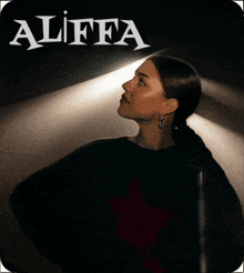 a woman stands in front of a sign that says ' aliffa ' on it