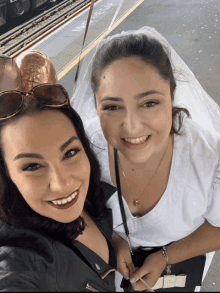 two women are posing for a picture with one wearing a veil