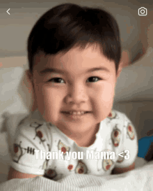 a baby laying on a bed with the words thank you mama < 3 below him