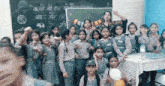 a group of children are posing for a picture in front of a chalkboard that says ' new years ' on it