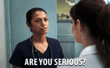 a nurse is talking to another nurse in a hospital room and the nurse is asking if the nurse is serious .