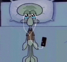 squidward from spongebob squarepants is wearing headphones and holding a cell phone .