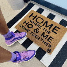 a person wearing purple shoes is standing on a door mat that says home where the ho & me come together