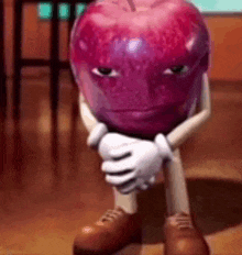 a cartoon apple with arms and legs is sitting on the floor with its head down .