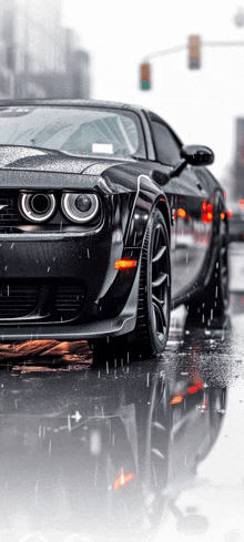 a black car is parked on a wet street in the rain