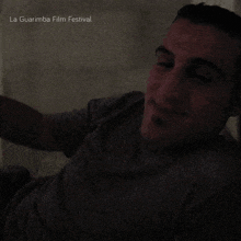 a man is smiling in a dark room with the words la guarimba film festival written above him