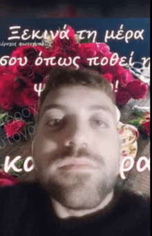 a man with a bouquet of red roses behind him