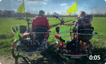 two people are riding bicycles in a field and the time is 5:05