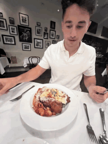 a man is sitting at a table with a plate of food in front of him