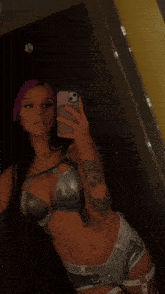 a woman taking a selfie in front of a mirror with her phone