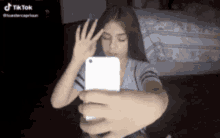 a girl is taking a selfie with a cell phone .