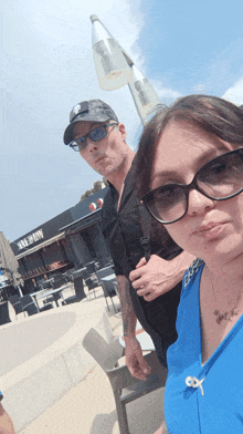 a man and a woman are posing for a picture in front of a building that says bakery on it