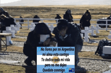 two people kneeling in a cemetery with a sign that says " no llores por mi argentina "