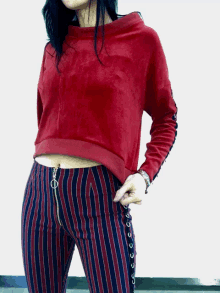 a woman wearing striped pants and a red sweatshirt