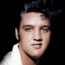 a close up of elvis presley 's face with a white shirt and black hair .