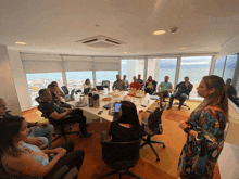 a woman stands in front of a group of people sitting around a table that says ibm