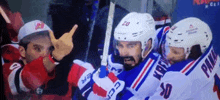 a hockey player with the number 50 on his jersey is giving the middle finger