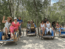 a group of people are riding in a row of carts