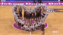 a group of cheerleaders forming a heart on a basketball court in front of a sign that says telekom dome bony