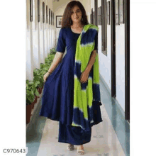 a woman is wearing a blue dress with a tie dye dupatta .