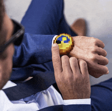 a man in a suit and tie is holding a pixel art watch on his wrist