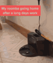 a robotic vacuum cleaner is sitting on the floor next to a box