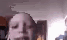 a blurry picture of a person 's face with their eyes closed in a room .