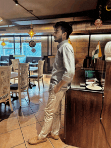 a man stands in a restaurant looking out the window