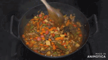 a man stirs food in a wok in a kitchen with the words made in animatica on the bottom right